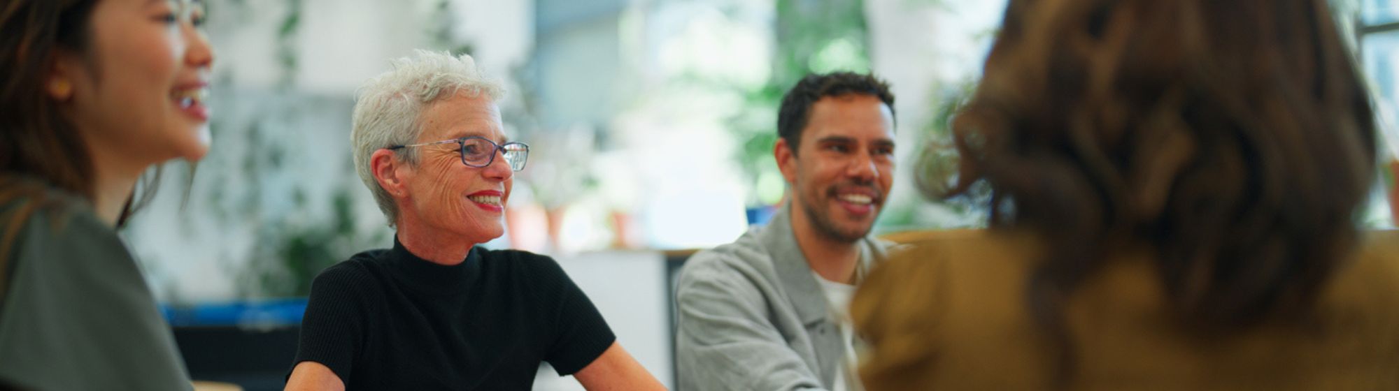Professionnels échangeant avec le sourire autour d’une table lors d’une rencontre business à foire de paris