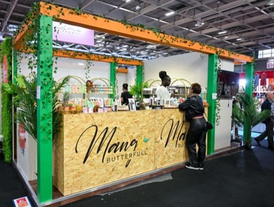 Stand coloré de Mang Butterfull à l'événement World in Paris, présentant des produits cosmétiques naturels avec des visiteurs interagissant avec les exposants.