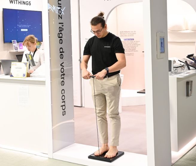 Démonstration sur le stand Withings à foire de paris : un visiteur mesure l’âge de son corps grâce à une balance connectée intelligente